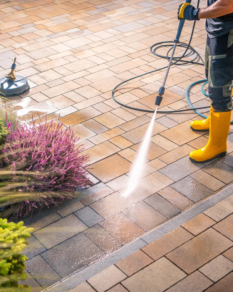 mycie myjką ciśnieniową kostki brukowej przez pracownika cleanhouse